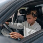 Een instructeur geeft rijlessen in Woensel, met leerlingen in de auto en een focus op diverse rijopleidingen.