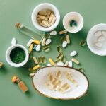 Een fles spermidine capsules op een tafel met groene bladeren op de achtergrond, symboliserend gezondheid en verjonging.