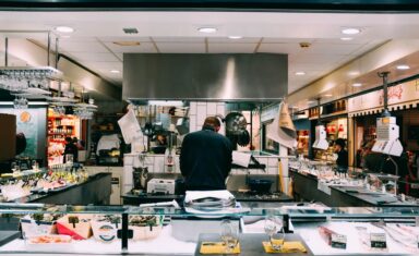 Moderne horeca-apparatuur zoals koeltoonbanken en ovens in een professionele keuken.