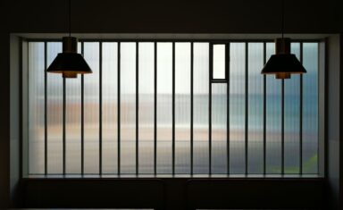 Minimalistische strakke hanglampen boven een moderne eettafel in een lichte woonkamer.